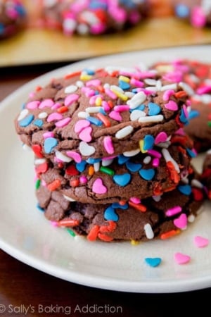 stack of chocolate cake mix cookies with sprinkles on a white plate