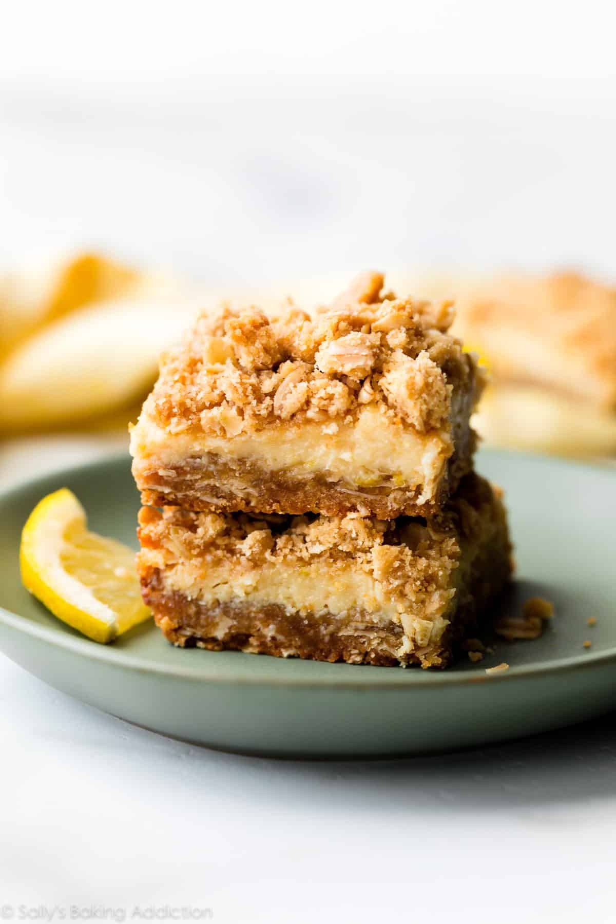 two creamy lemon crumble bars on a green plate