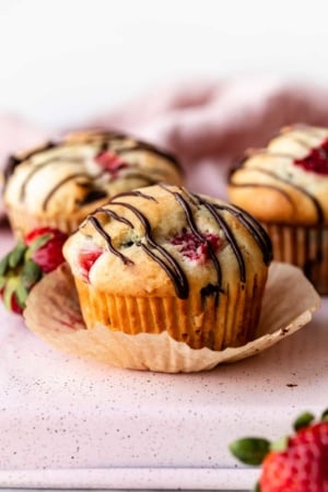 strawberry and chocolate chip muffins with chocolate drizzle on top