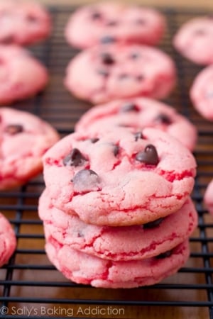 stack of strawberry cookies with chocolate chips on a black cooling rack