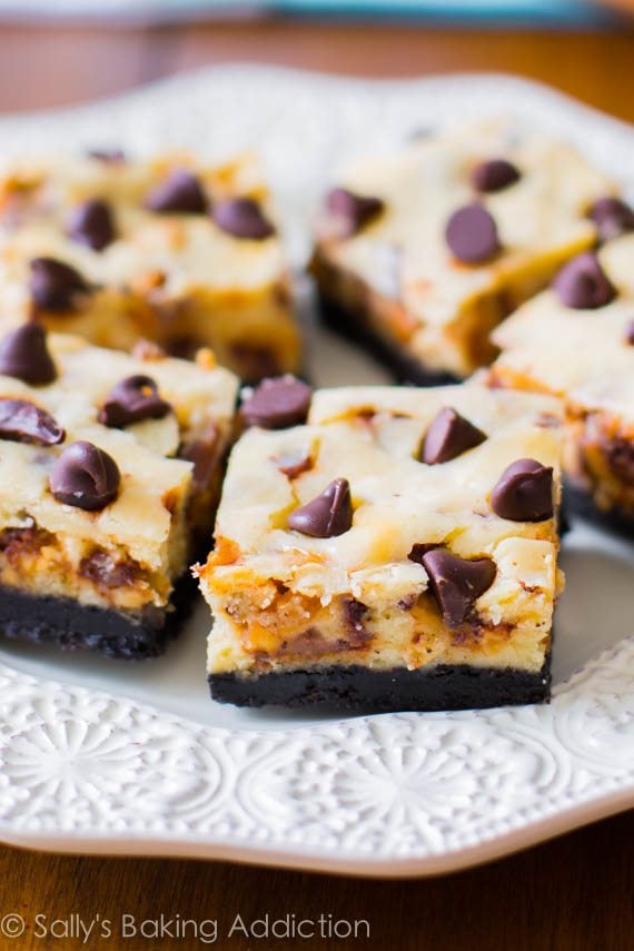 Snickers cheesecake bars on a white plate