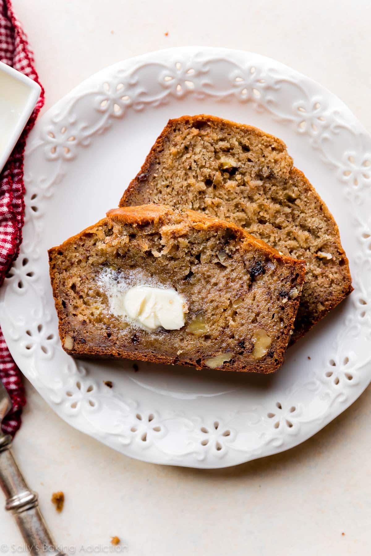 2 slices of banana bread with butter on a white plate