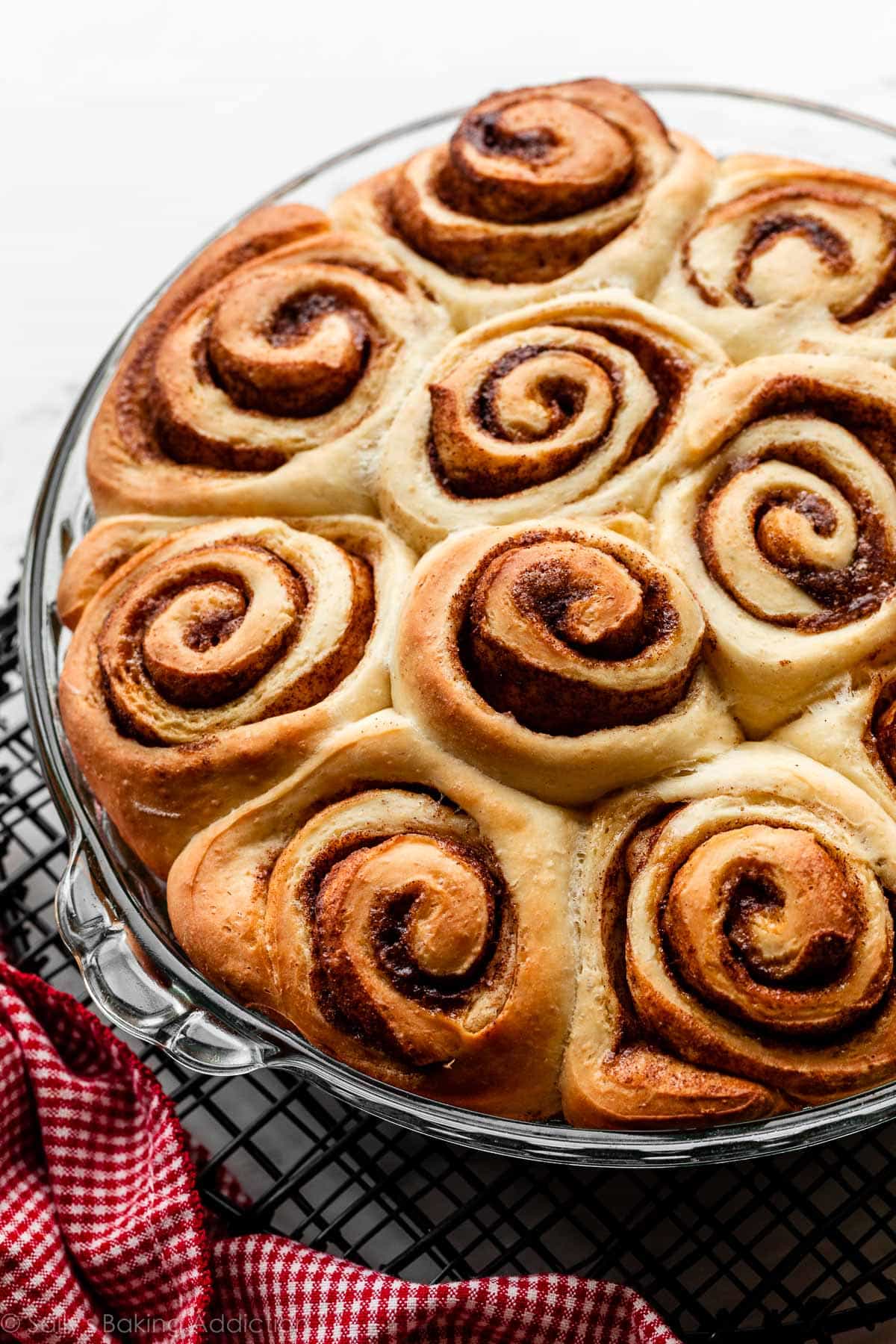 glass pie dish of cinnamon rolls before icing them.