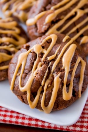 chocolate cookies with peanut butter drizzle on a white plate