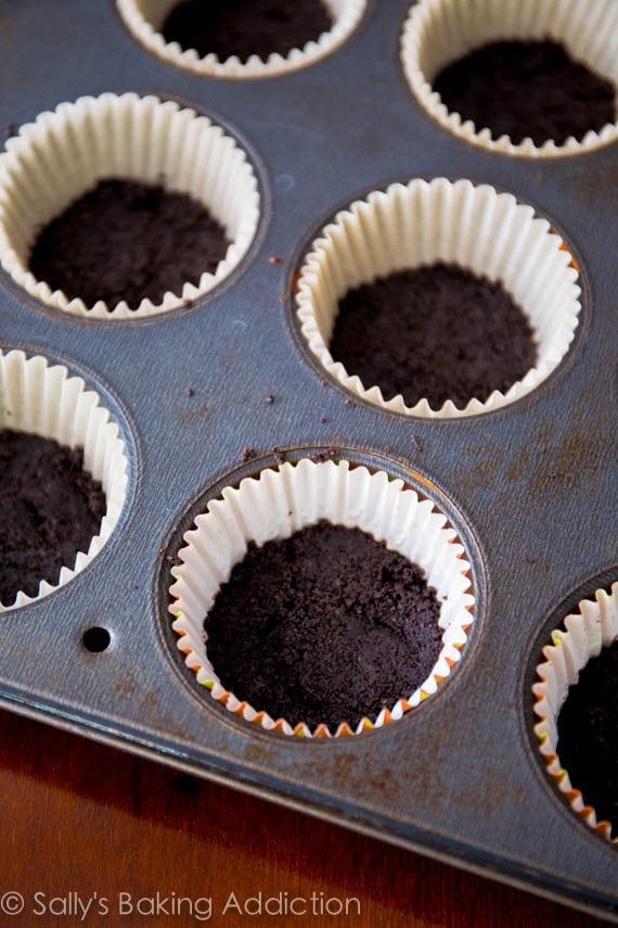 Oreo cookie crusts in cupcake liners in a cupcake pan