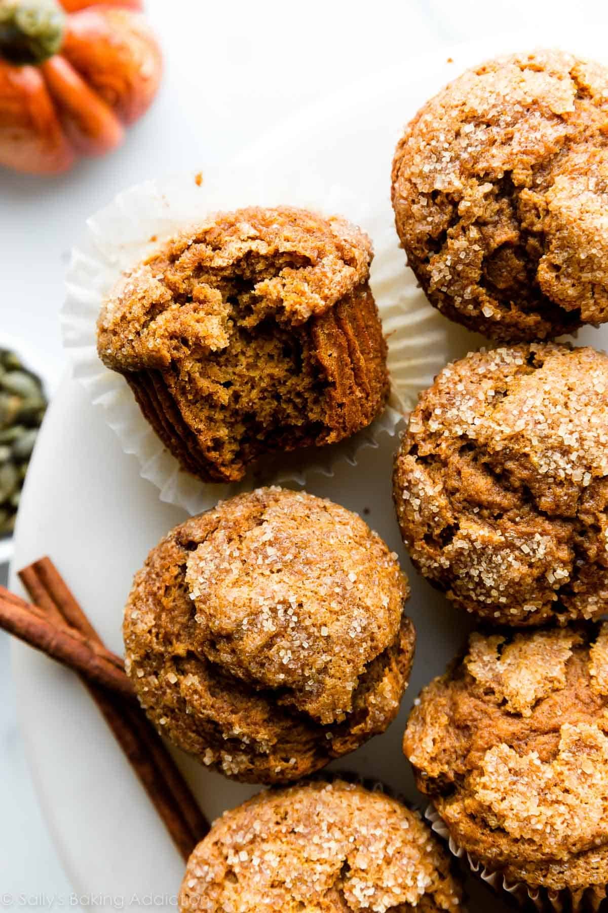 pumpkin muffins on white plate with cinnamon sticks.