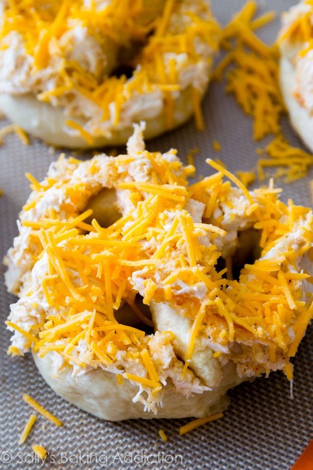 soft pretzels topped with cheesy crab dip on a silpat baking mat before baking