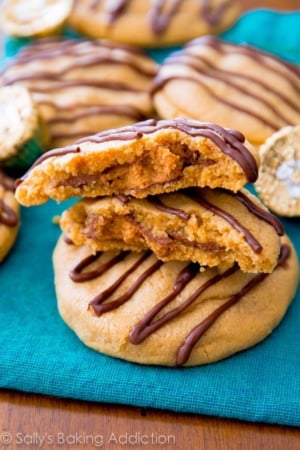 stack of Reese's stuffed peanut butter cookies with one broken in half showing the peanut butter cup inside