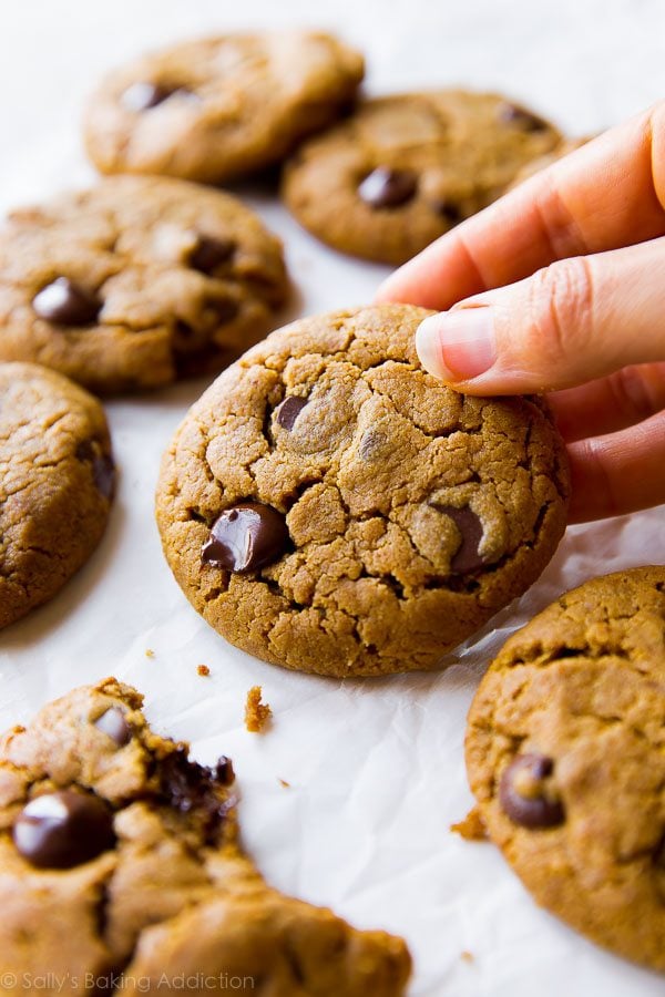 hand holding an almond butter chocolate chip cookie