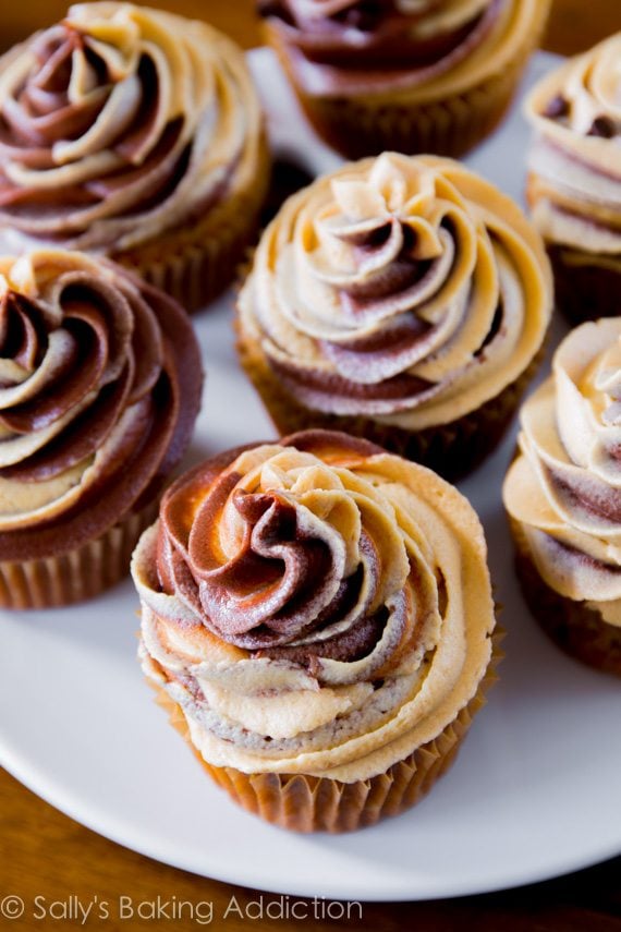 banana chocolate chip cupcakes topped with chocolate peanut butter swirl frosting on a white plate