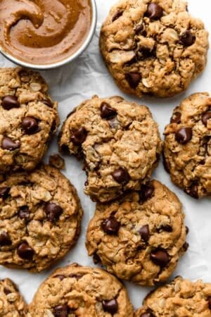 8 flourless peanut butter oatmeal cookies on white parchment paper.