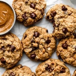 7 flourless peanut butter oatmeal cookies on white parchment paper.