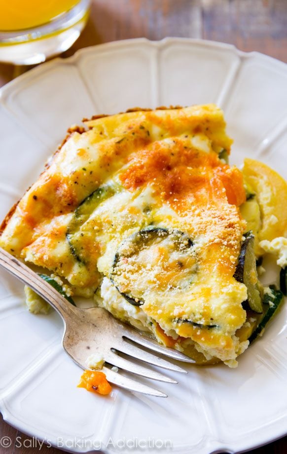 slice of crustless veggie quiche on a white plate with a fork