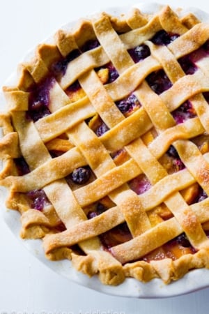 blueberry peach pie in a white pie dish