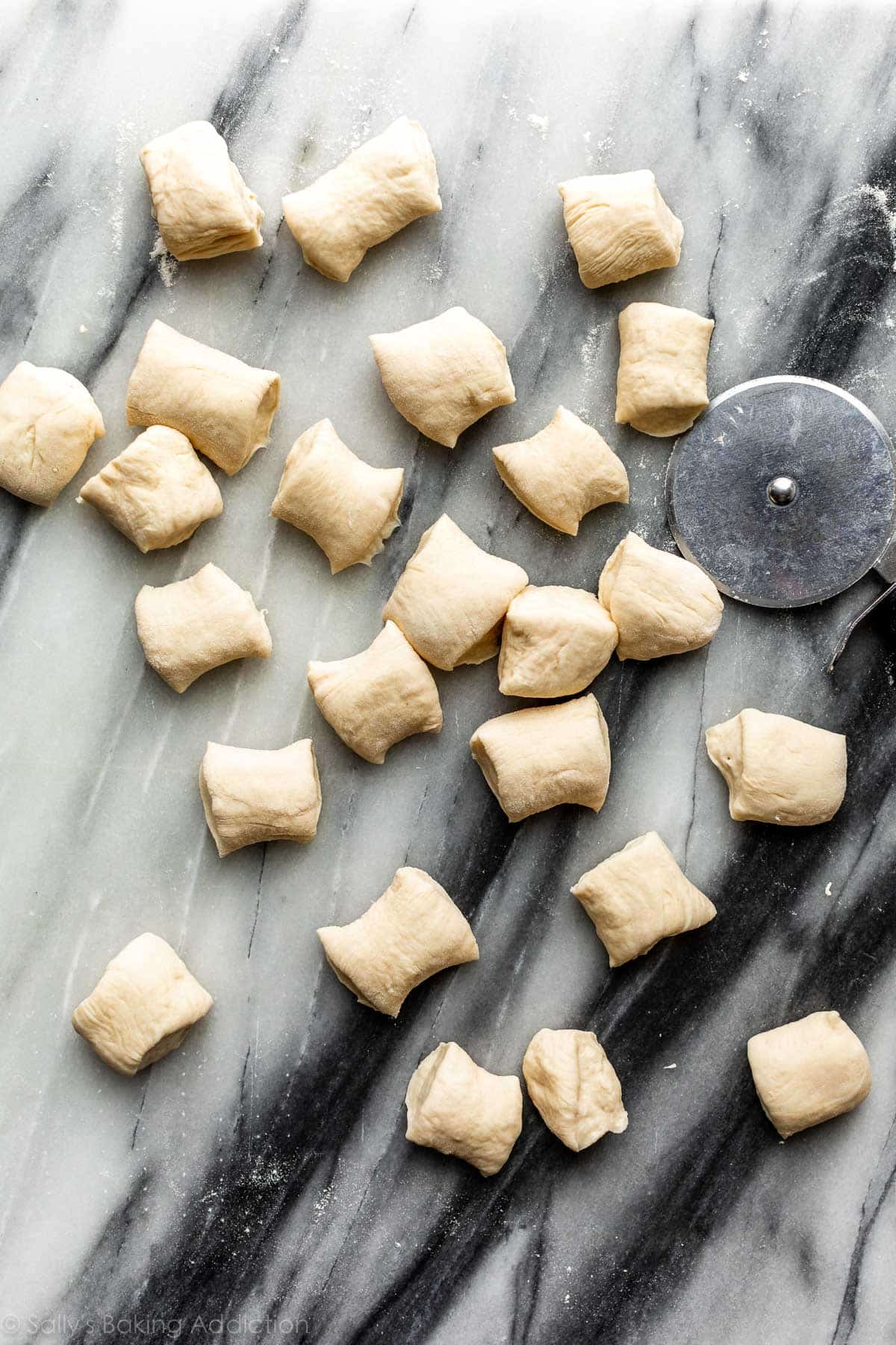 bite size dough pieces on a marble cutting board