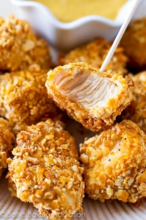 pretzel crusted chicken bites on a white plate