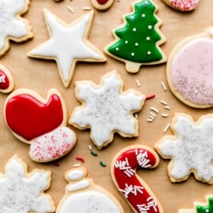 decorated Christmas sugar cookies including Christmas tree, red mittens, stars, ornaments, and snowflakes with icing.