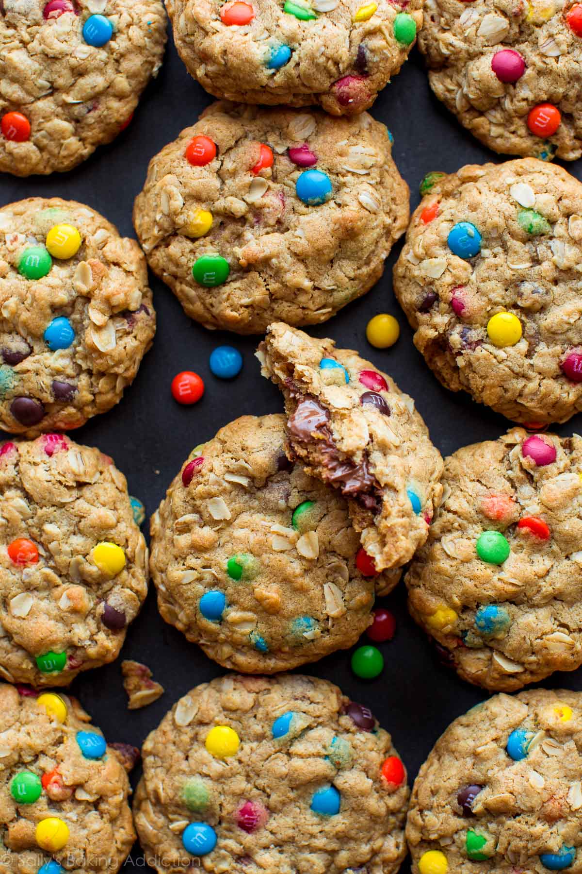 overhead image of monster cookies with one cookie broken in half showing a peanut butter cup inside