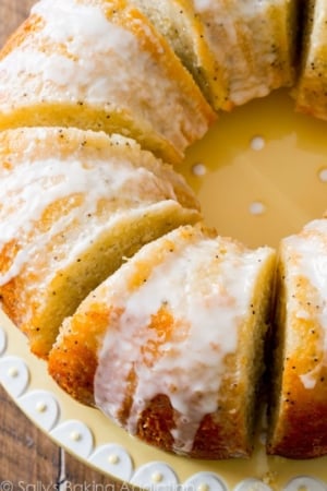 overhead image of lemon poppy seed bundt cake cut into slices on a yellow plate