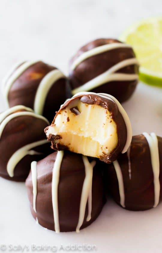 dark chocolate key lime pie truffles with a bite taken from one showing the inside