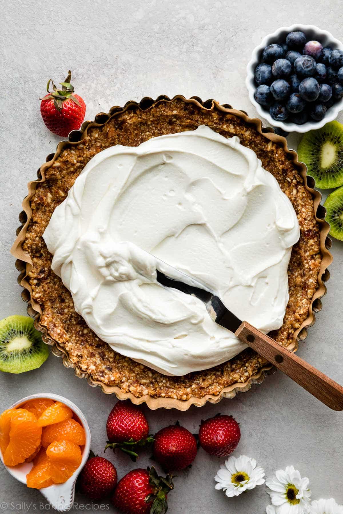 spreading yogurt into no bake date and nut tart crust.