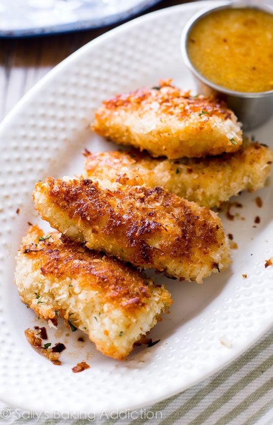 coconut chicken on a white plate with dipping sauce