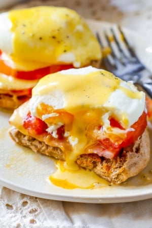 eggs benedict on a white plate with a fork