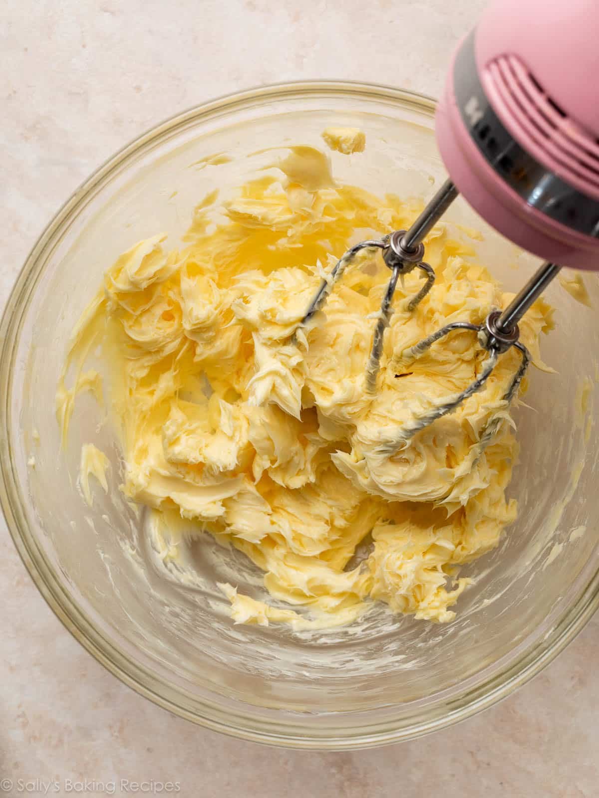 butter in glass bowl with pink mixer.