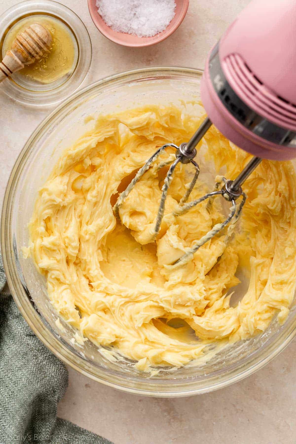 honey butter whipped in glass bowl with pink hand mixer.