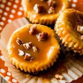 salted caramel pumpkin cheesecakes on an orange and white plate