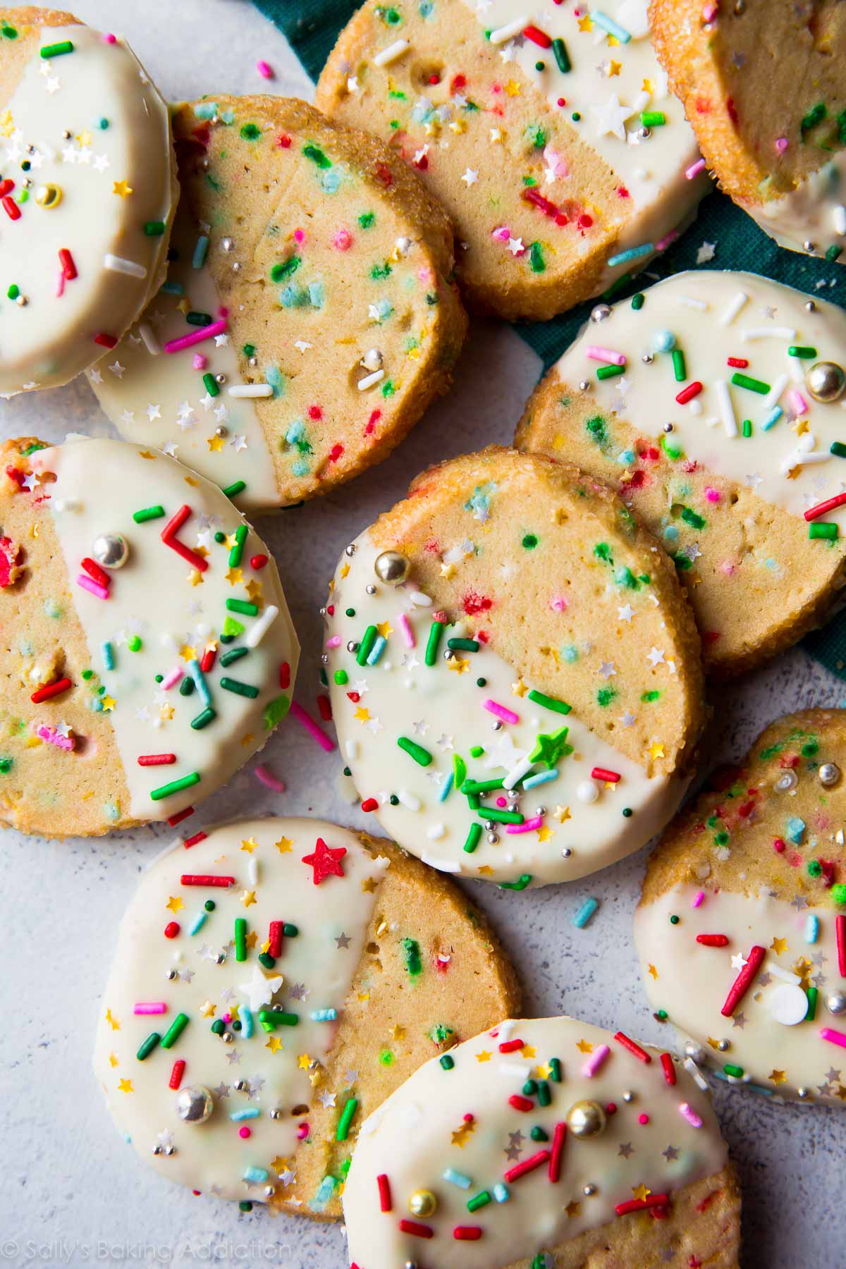 overhead image of funfetti slice and bake cookies with half of each cookie dipped into white chocolate and topped with sprinkles