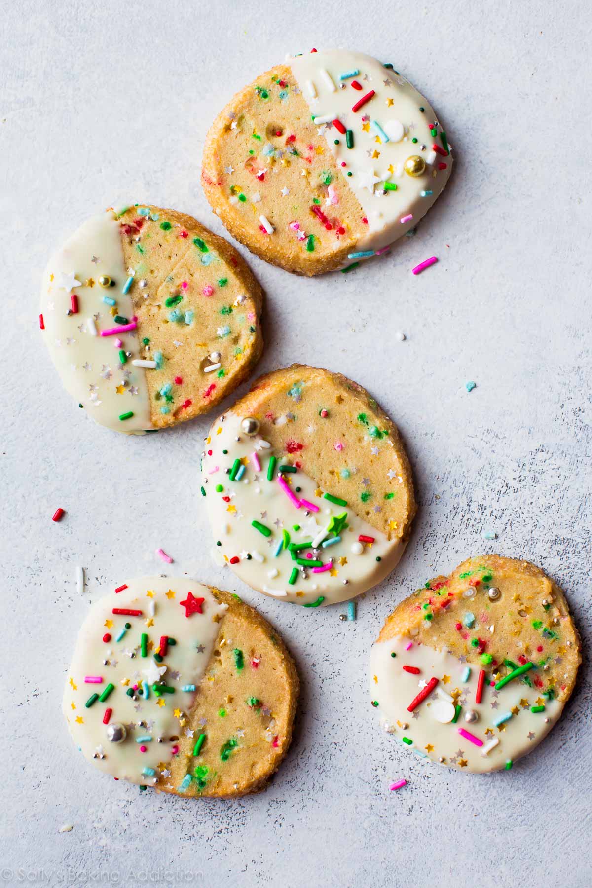 funfetti slice and bake cookies with half of each cookie dipped into white chocolate and topped with sprinkles