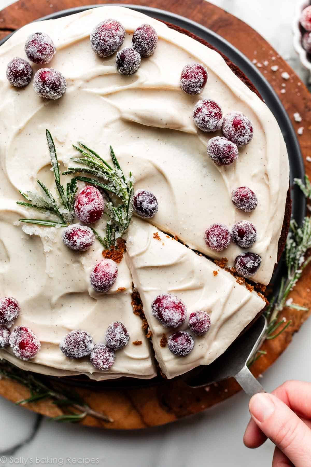 overhead photo of round gingerbread cake with slice cut out and being removed.