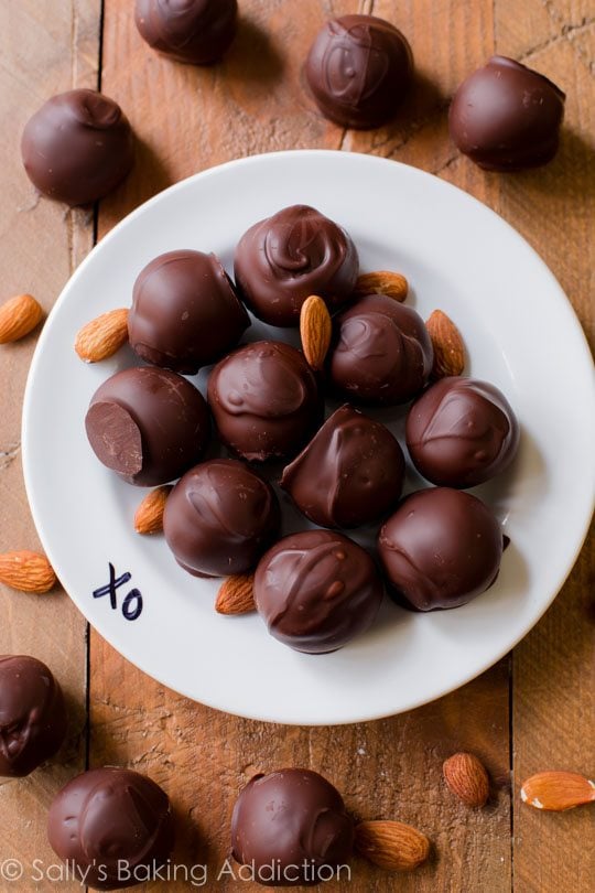 overhead image of dark chocolate almond truffles on a white plate