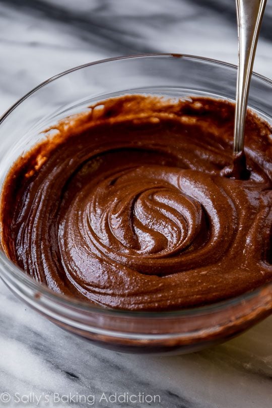 chocolate cake batter in a glass bowl with a spoon