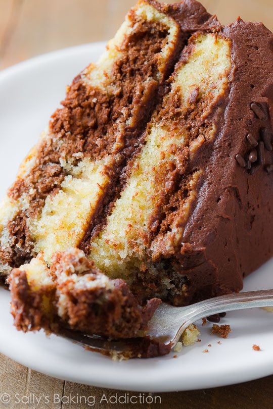 slice of marble layer cake on a white plate with a fork