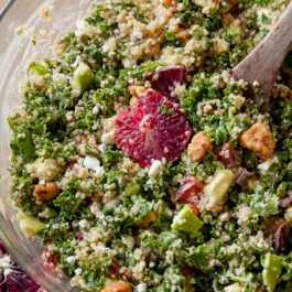 blood orange avocado quinoa & kale salad in a glass bowl