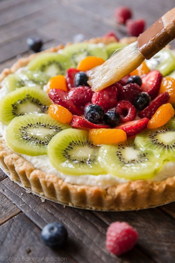 brushing fruit glaze onto fresh fruit tart