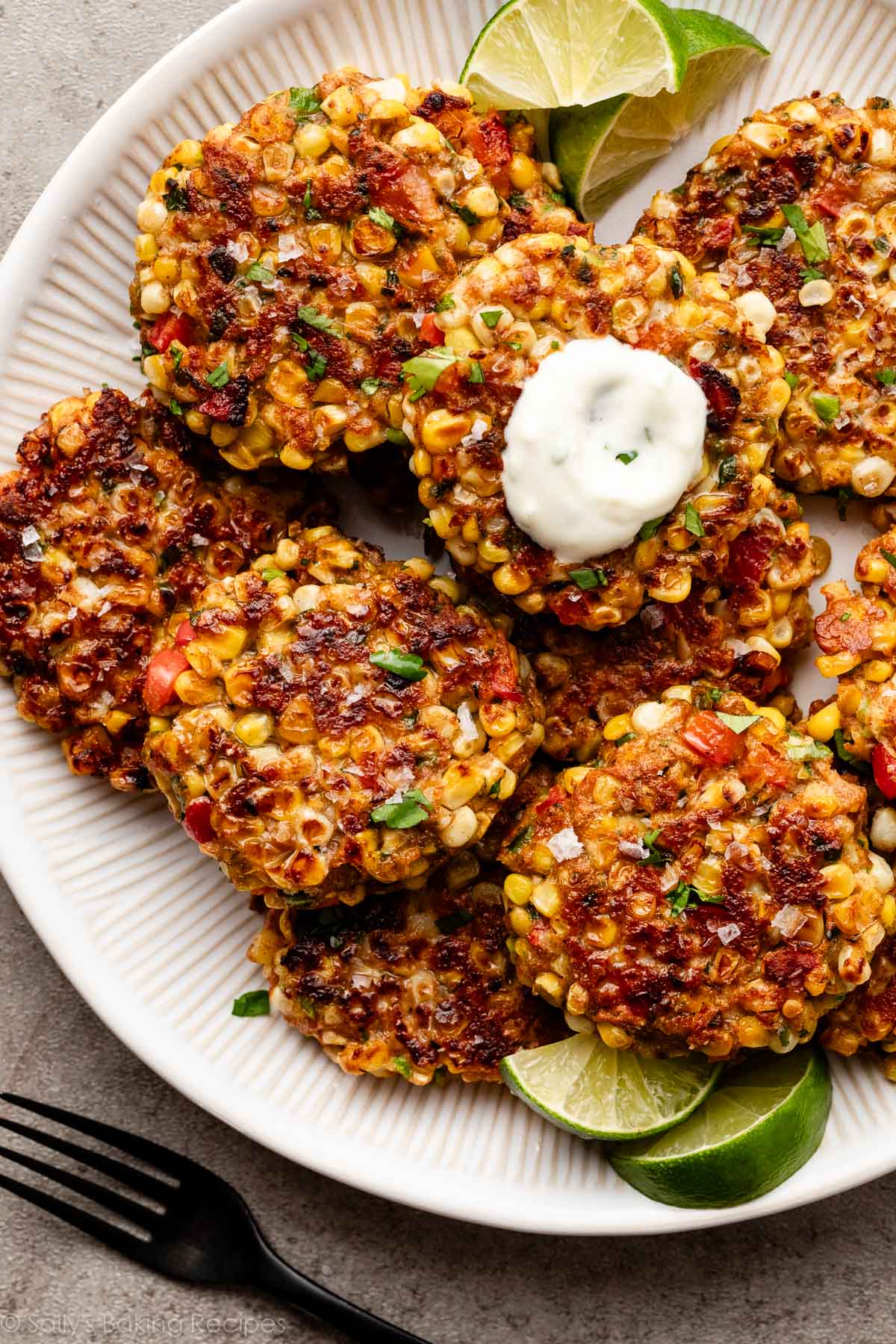 corn fritters on plate with yogurt sauce.