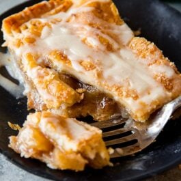 slice of apple slab pie on a black plate with a fork