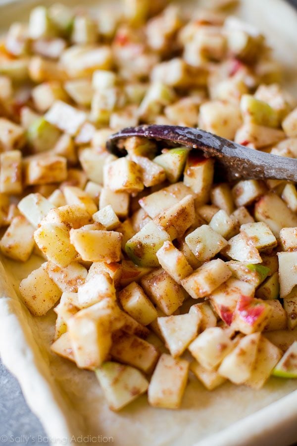 apple slab pie filling in baking pan with wood spoon