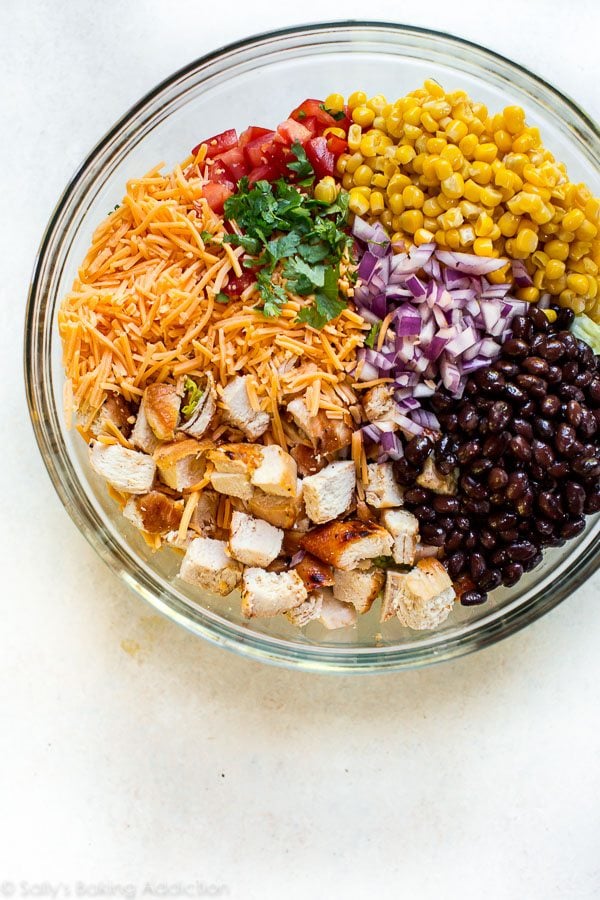 overhead image of all ingredients for southwestern chopped chicken salad in a glass bowl before mixing