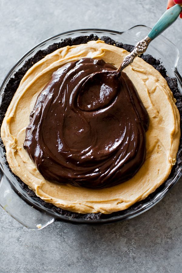 spreading chocolate ganache onto peanut butter filling