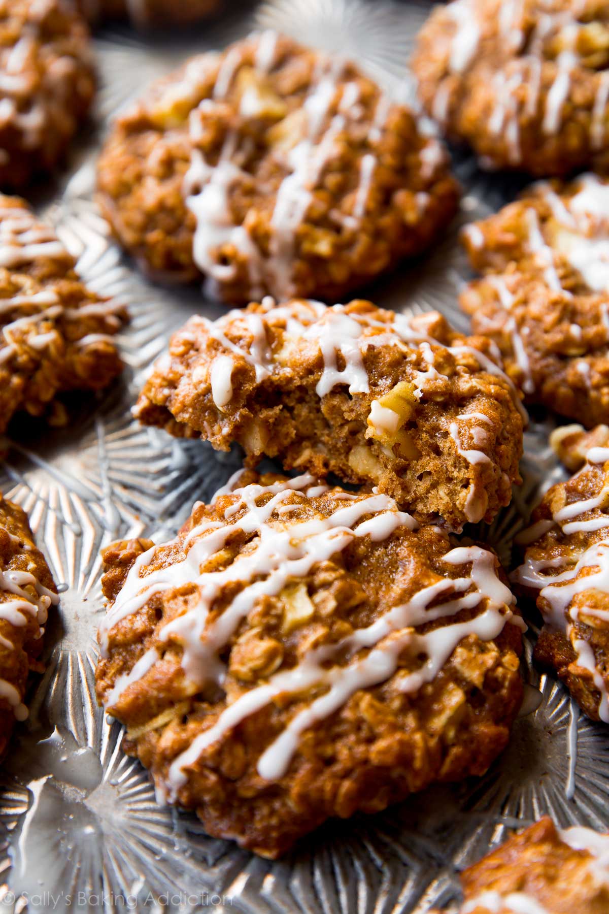 apple cinnamon oatmeal cookies with maple icing on a baking sheet