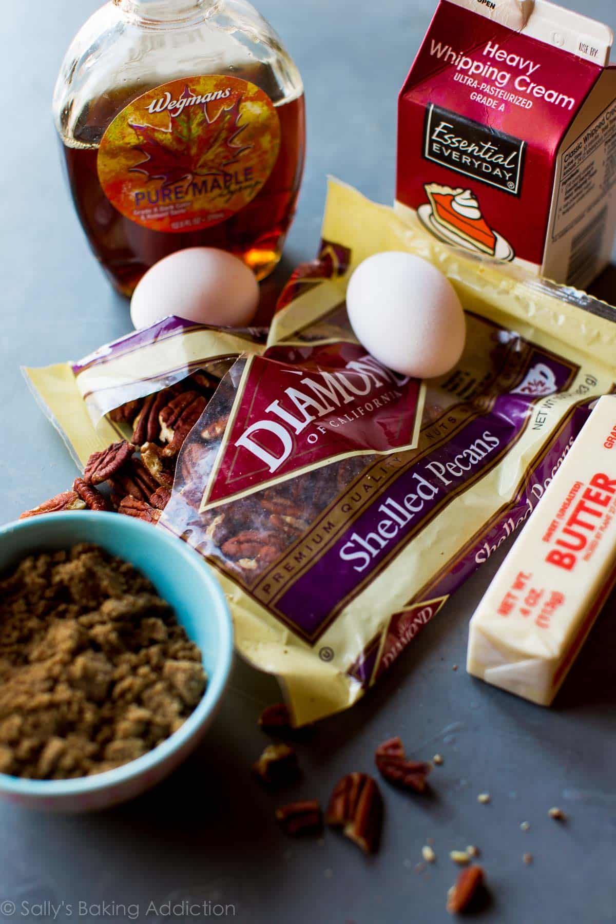 ingredients for brown butter pecan pie bars including pecans, brown sugar, maple syrup, eggs, butter, and heavy cream