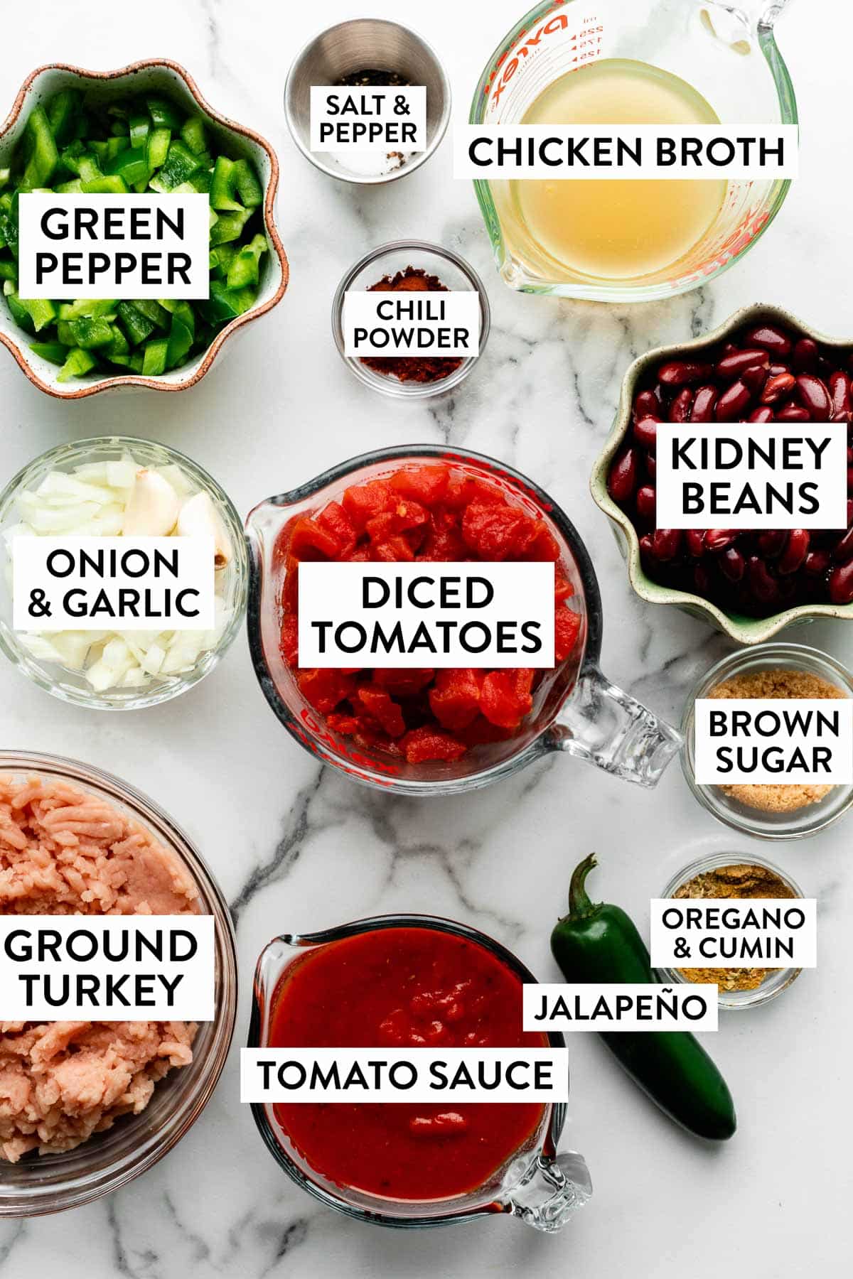 ingredients measured in bowls on counter including kidney beans, chicken broth, diced tomatoes, chopped onion and green peppers, herbs, and more.