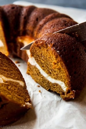 pumpkin cream cheese bundt cake with a knife cutting a slice