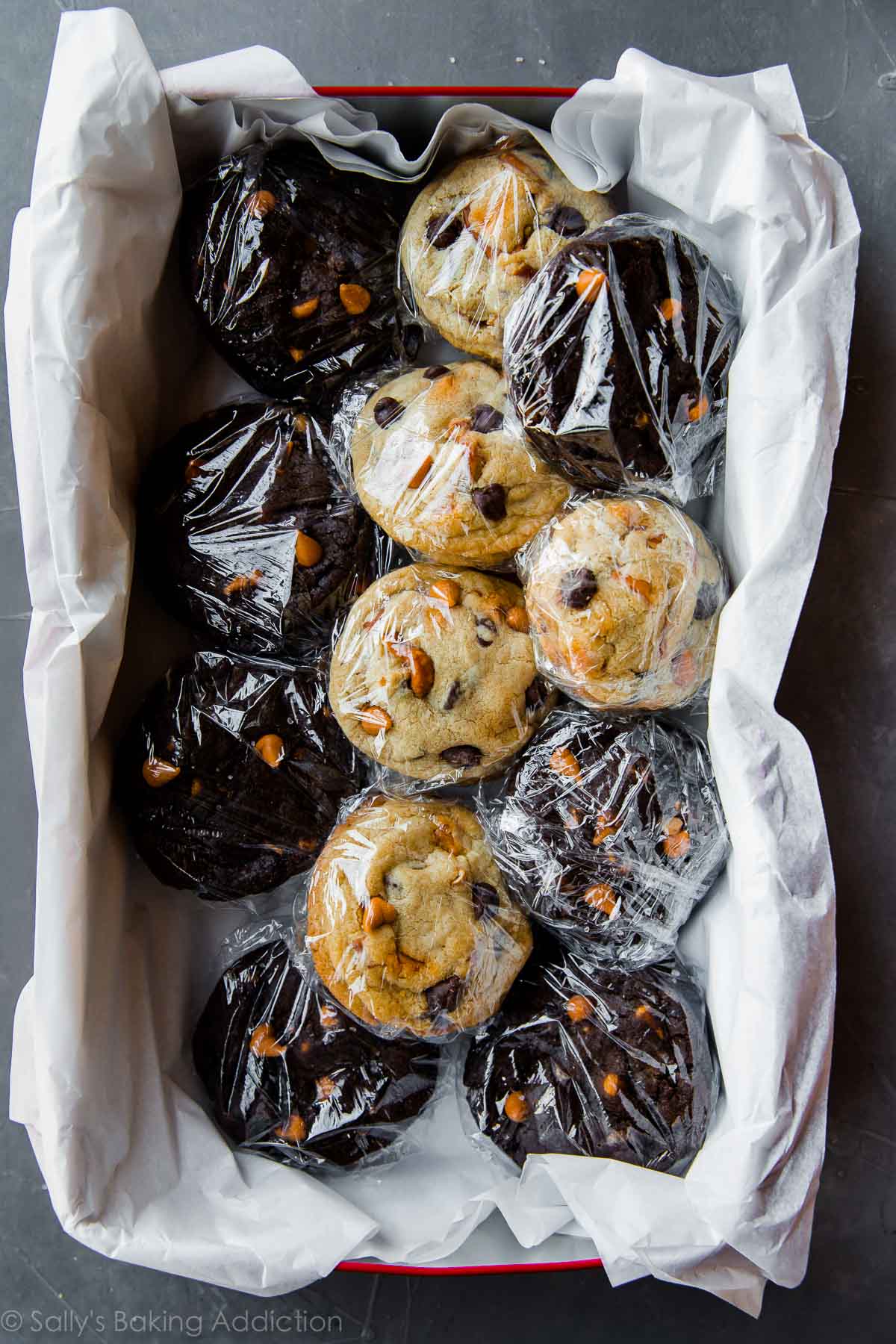 cookies packaged for shipping in plastic wrap with tissue paper in a tin box