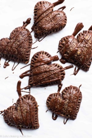 overhead image of heart shaped chocolate hand pies drizzled with chocolate topping