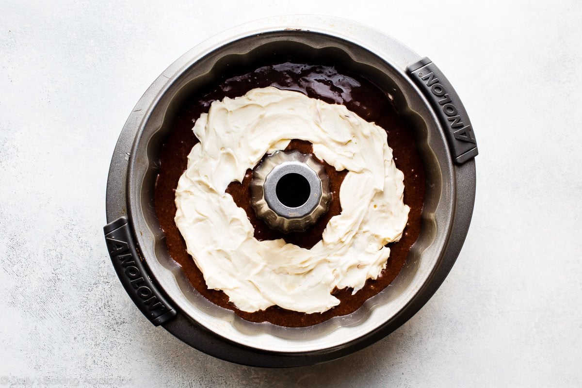 cream cheese layer on top of chocolate cake batter in a bundt pan